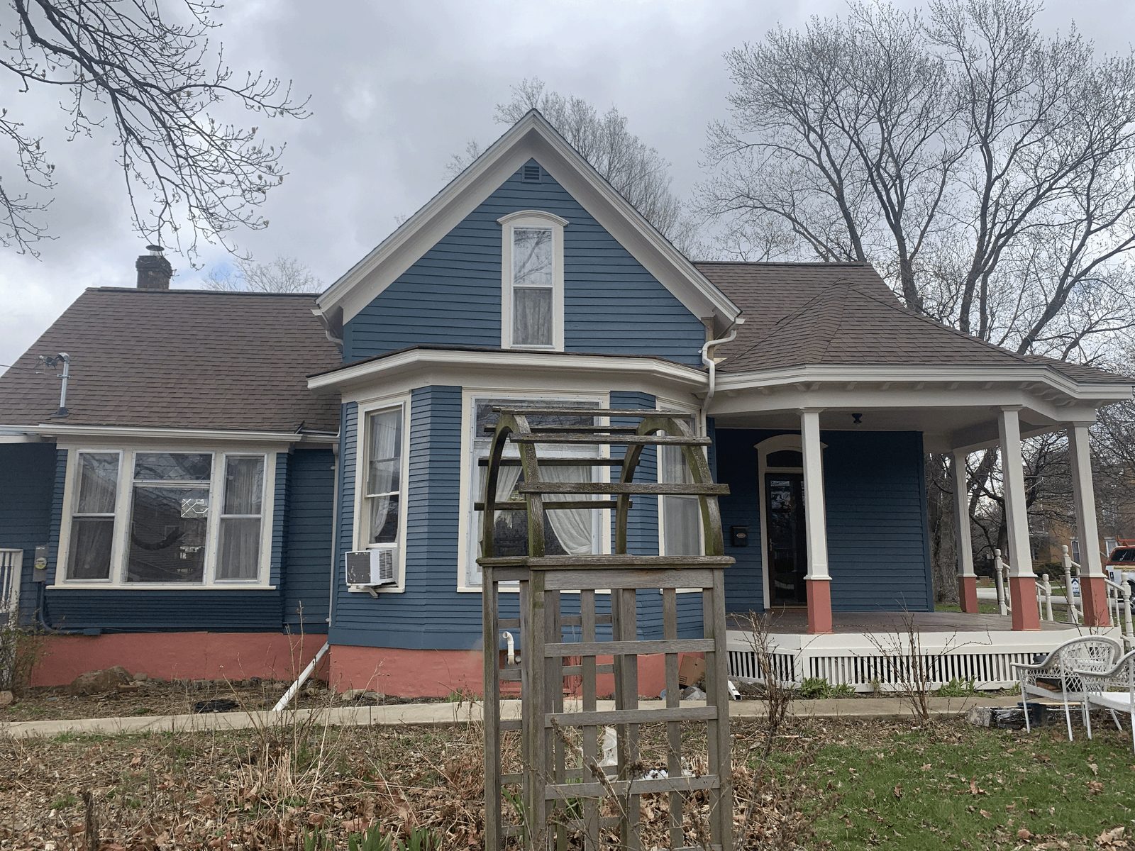 Historic Bloomington home repainted in navy with white trim and terracotta porch