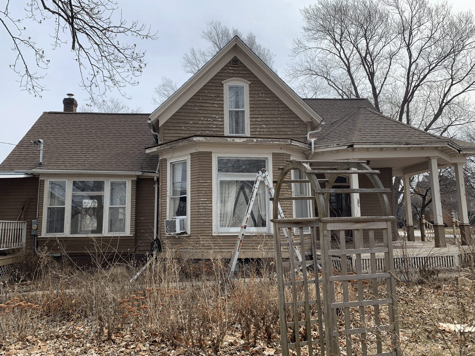 Before: faded, peeling brown siding on a historic home