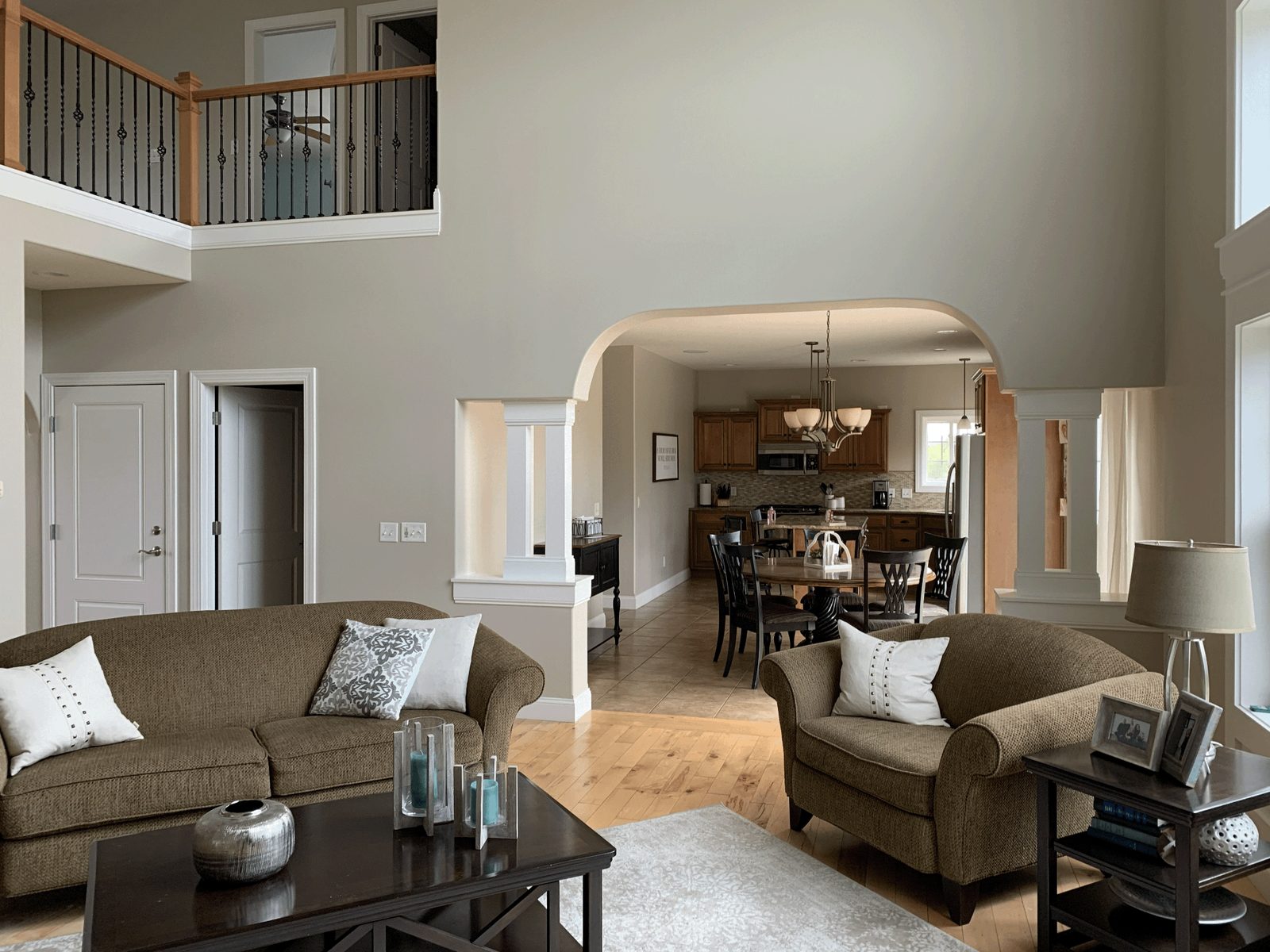 Freshly painted two-story living room in warm greige with white trim